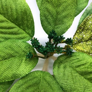 Fleur de Noël artificielle aux feuilles vertes et paillettes vert foncé sur fond blanc