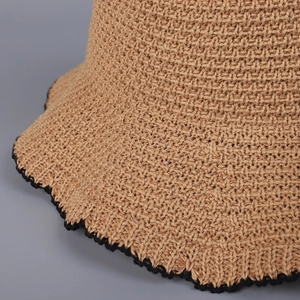 Khaki knit sun hat with black scalloped wavy trim shown in a detailed close-up shot