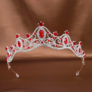 Classical silver bridal crown with ruby red and clear crystals on dark silk fabric