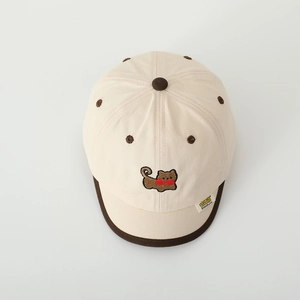 Détail de broderie chiot mignon sur casquette enfant en coton beige avec bord brun