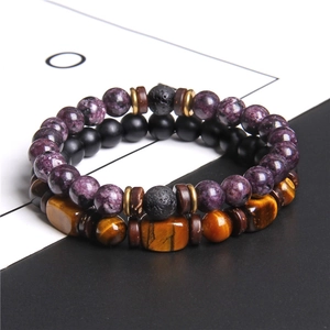 Macro detail of men's beaded bracelet set featuring tiger eye stones and purple beads
