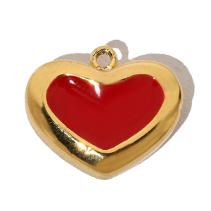 Macro shot of a red enamel heart pendant with golden metal edges for jewelry DIY
