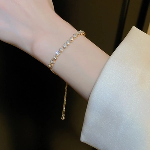 Close-up of elegant gold wavy bracelet with rhinestones worn on a female wrist
