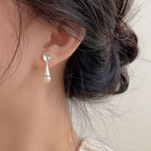 Close-up of elegant S925 silver pearl drop earrings worn on a female model