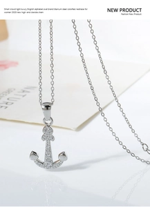 Macro shot of silver anchor pendant with white zircon inlays on a titanium steel chain
