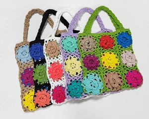 Close-up of five handmade crochet tote bags with large floral patterns in assorted colors