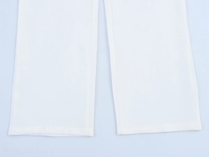 Close-up of white straight-leg trousers hem with smooth fabric and neat stitching
