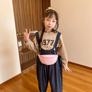 Pink quilted leather waist bag for children shown in a cozy indoor lifestyle setting
