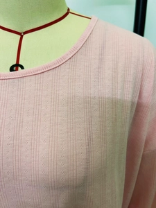 Detail of pink knit pajama top showing hollow stripe texture and soft round neckline