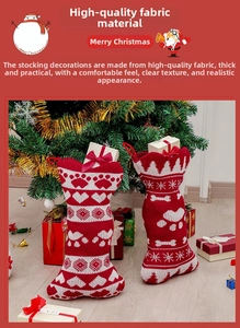Close-up of knitted bone-shaped Christmas stockings with paw prints and snowflake patterns