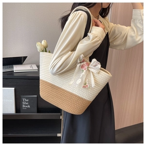 Detail of woven tote bag featuring beige and brown tones with floral lace bow