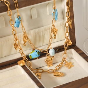 Collier en acier doré avec pendentifs marins étoile de mer et tortue dans son écrin