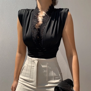 Dettaglio del body nero da donna con scollo a V, inserti in pizzo e vita a pieghe chic