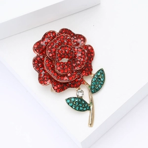 Elegant gold-tone rose brooch with red crystal petals and green rhinestone leaves