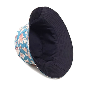 Detail of floral bucket hat with pink cherry blossom print on navy blue canvas fabric