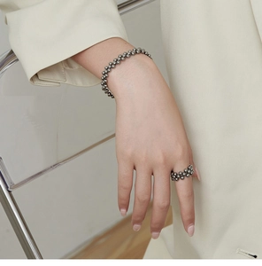 Detail view of multi-layer beaded bracelet and ring set in polished titanium steel