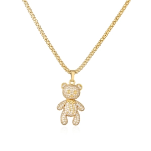 Close-up of golden teddy bear pendant with micro-paved zircons and popcorn chain