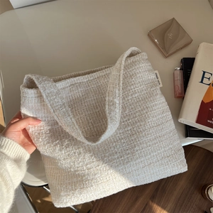 Détail du sac bandoulière en tweed crème avec étiquette tissée simple wish élégante