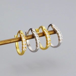 Close-up of gold and silver large hoop earrings with sparkling cubic zirconia stones