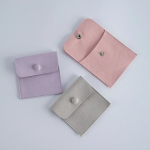 Three velvet jewelry pouches with snap button closure in pink purple and grey colors
