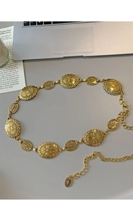 Detaillierte Makroansicht der goldenen Taillenkette mit gravierten ovalen Metallelementen