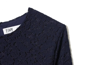 Gros plan sur la texture dentelle florale du col rond et de l'épaule de la robe bleue