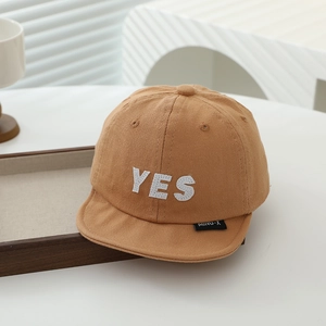 Detailed view of the 'YES' embroidered patch on this camel cotton baby baseball cap