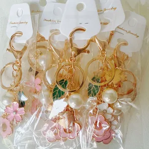 Close-up of floral alloy keychain set with rhinestone petals and gold lobster clasp
