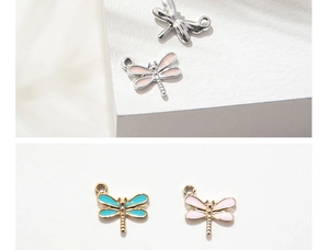 Macro detail of colorful dragonfly pendant charms in gold and silver finish with enamel