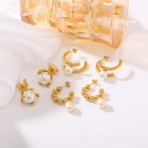French vintage gold C-shape titanium steel earrings with white pearls on white fabric