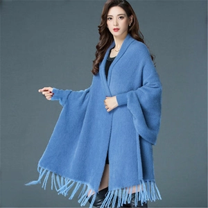 Close-up of blue faux mink fur knit poncho featuring elegant tassel fringe details