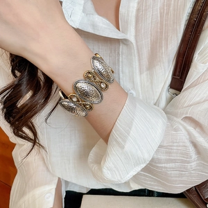 Detail view of vintage hammered metal heart bracelet with gold rope trim and crystals