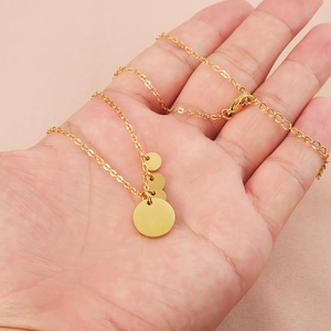 Golden stainless steel necklace featuring triple circular pendants on a classic link chain