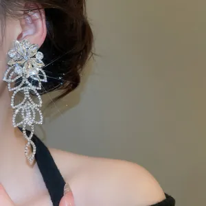 Élégantes boucles d'oreilles fleurs en argent et cristaux sur un mannequin en studio