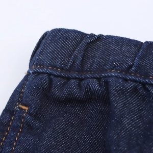 Vue détaillée du denim bleu foncé avec coutures orange et taille élastique confortable