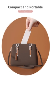 Compact white folding handheld mirror being placed into a bag showing portability