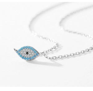 Macro detail of silver necklace featuring micro-pave turquoise evil eye pendant