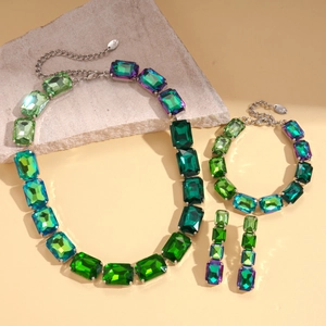 Detail showing vintage emerald and violet crystal jewelry set with swan charm accents