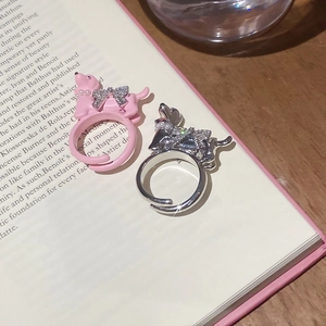 Detail of cute puppy rings with pearl bow collars in pink enamel and silver finish