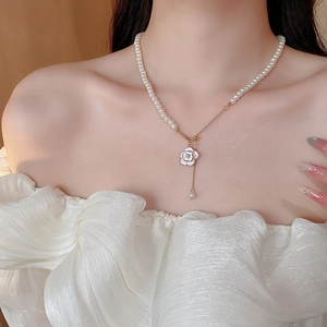 Detail of camellia pearl necklace on model's neck featuring elegant French luxury style