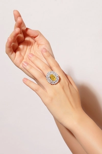 Close-up of s925 silver ring featuring an oval yellow stone in a floral cluster design