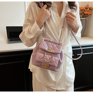 Close-up of lilac quilted backpack with gold chain strap and dual turn-lock pockets