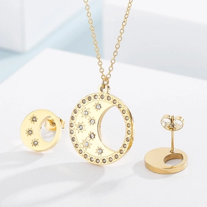 Gros plan d'une parure dorée lune et étoile avec oxydes de zirconium sur socle blanc