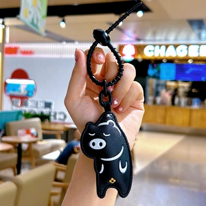 Cute black pig cartoon leather keychain with a stylish black spiral coil and gold floral motif