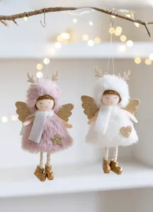 Detail of plush angel and reindeer ornaments with gold wings on a rustic branch