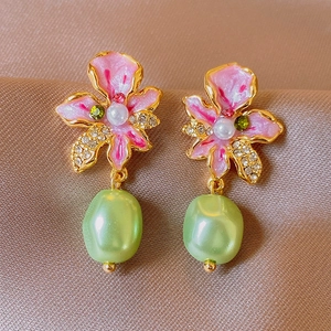 Detail of vintage enamel flower earrings with pearls and green baroque beads