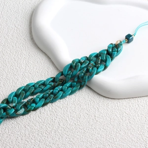 Detail of teal marble acrylic phone chain with gold metal ring on white background