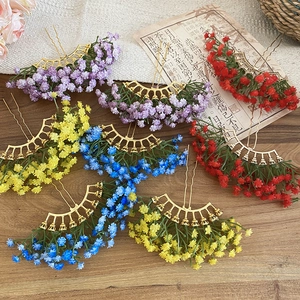 Close-up of elegant floral hair pins with colorful blooms on a rustic wooden background
