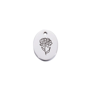 Macro detail of silver oval stainless steel pendant featuring carnation flower engraving