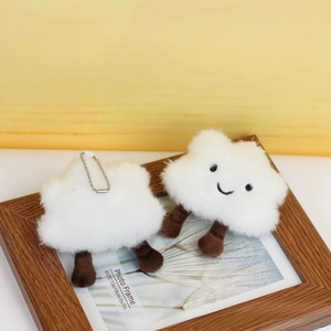 Detailed view of white plush cloud charms with beaded chains on a wooden frame